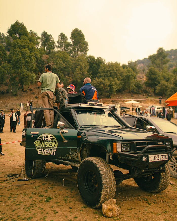 All-terrain vehicles and participants at an outdoor off-road event during the day.