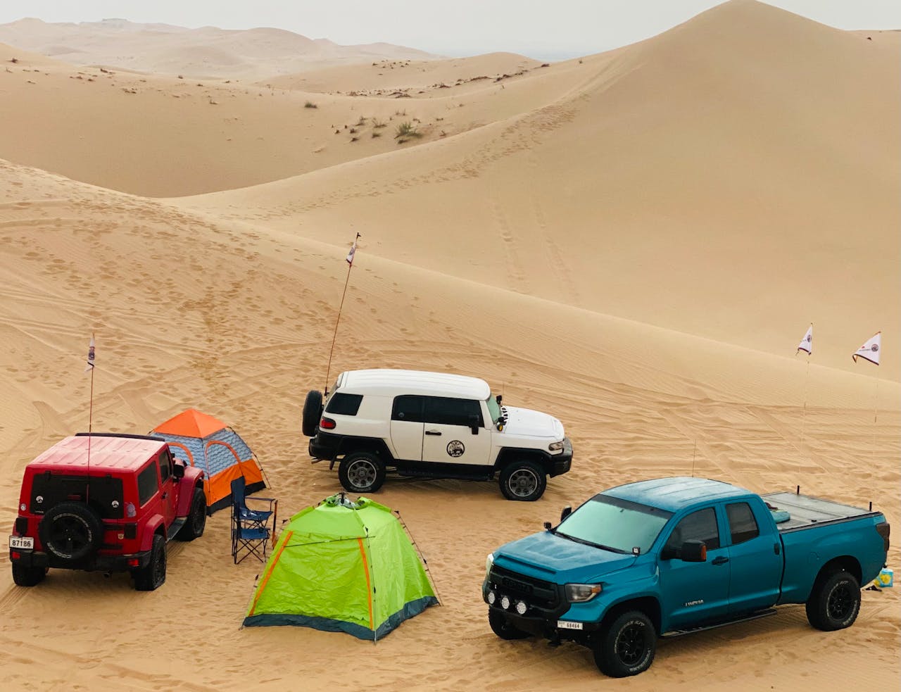 Off-road vehicles and tents in Abu Dhabi desert landscape perfect for adventure trips.
